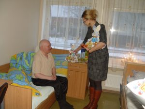 Doradca mer Elżbieta Jabłońska wręcza świąteczne prezenty pensjonariuszom ośrodka
