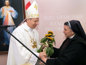 Siostra Michaela wręcza arcybiskupa Gruszasa złociste słoneczniki Fot. Marian Paluszkiewicz