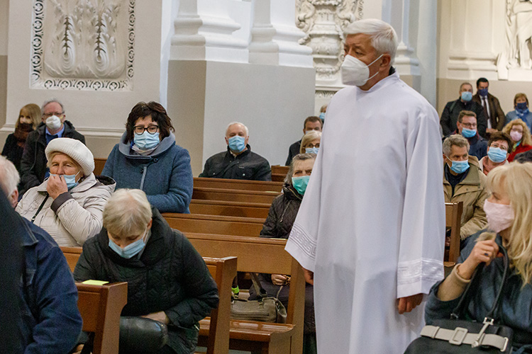 Starsi ludzie w maskach siedzą w kościele pomimo pandemii