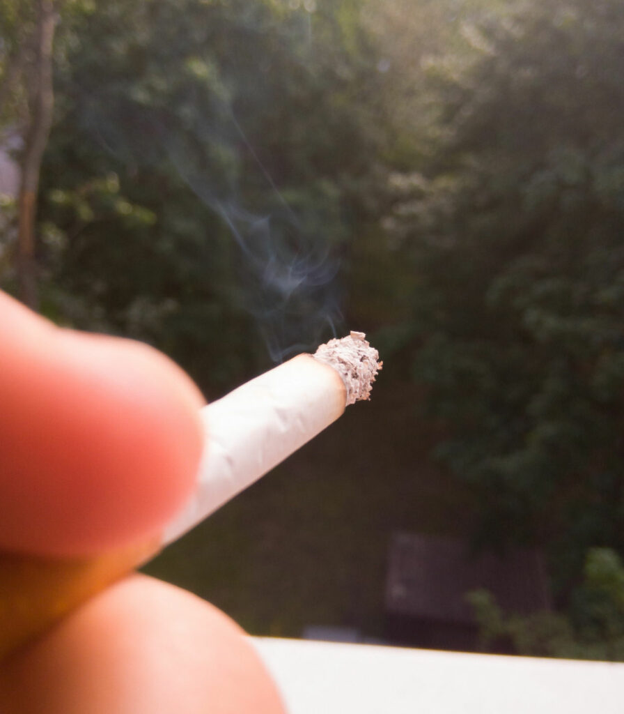 Dłoń trzymająca zapalony papieros