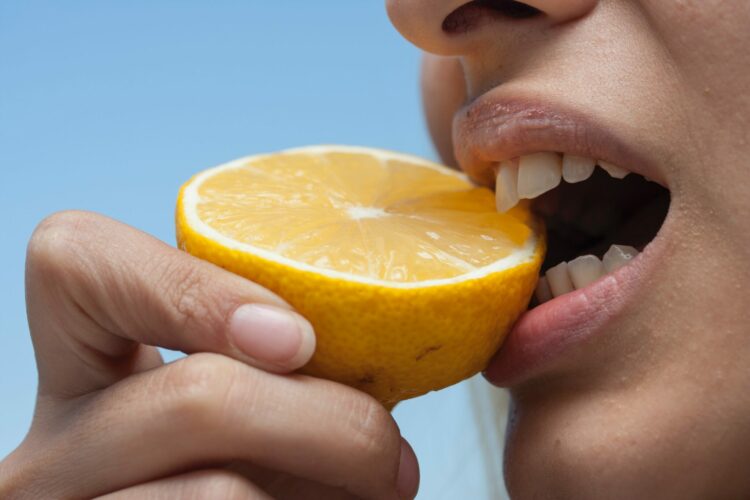 person holding orange lemon fruit during daytime