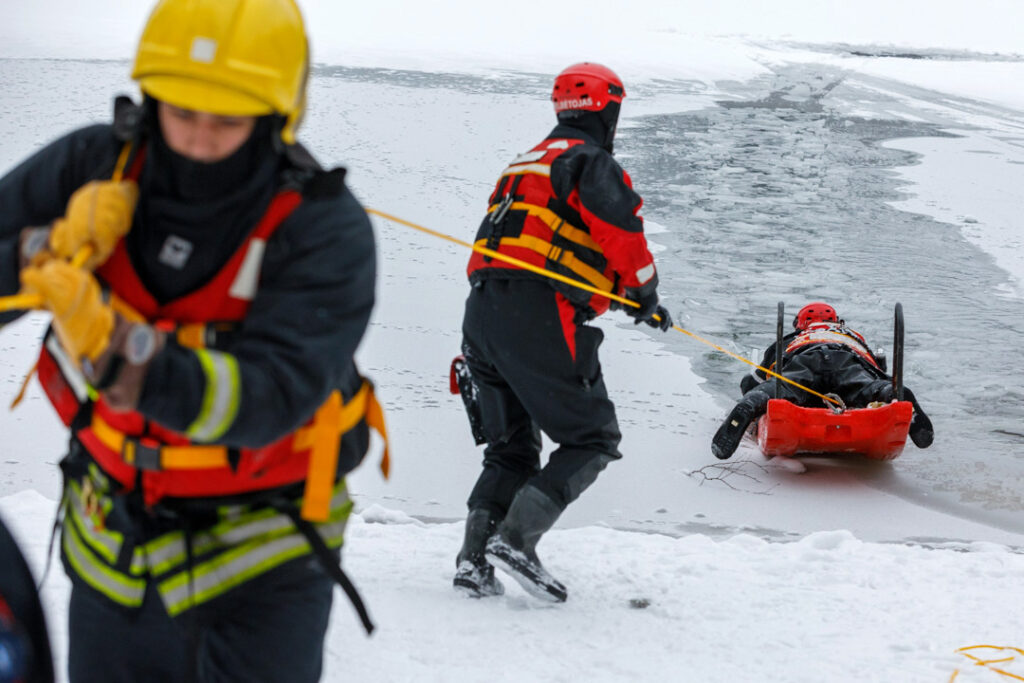 Litewska straż pożarna przeprowadza demonstrację akcji ratunkowej na zamarzniętej tafli jeziora