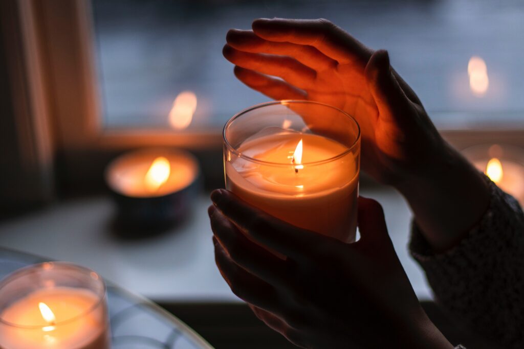Dłonie trzymające rozpaloną świeczkę