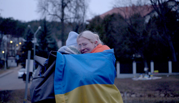 Kobieta z flagą Ukrainy obejmuje kobietę.