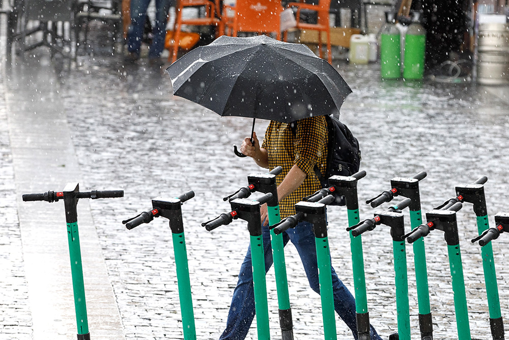 Kobieta idąca z parasolem.