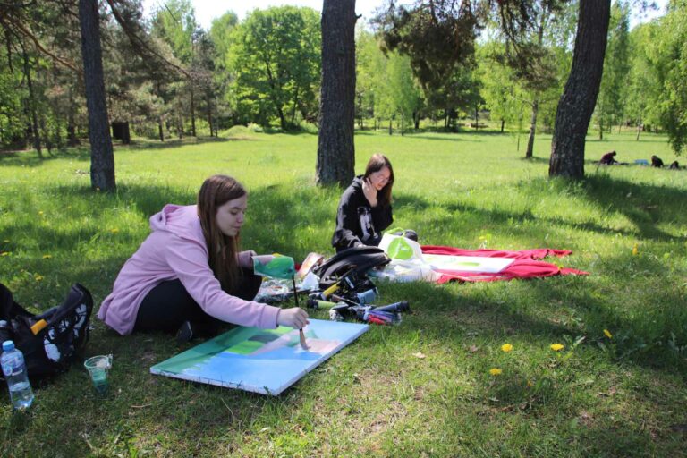 Dziewczynki malują na łonie przyrody.