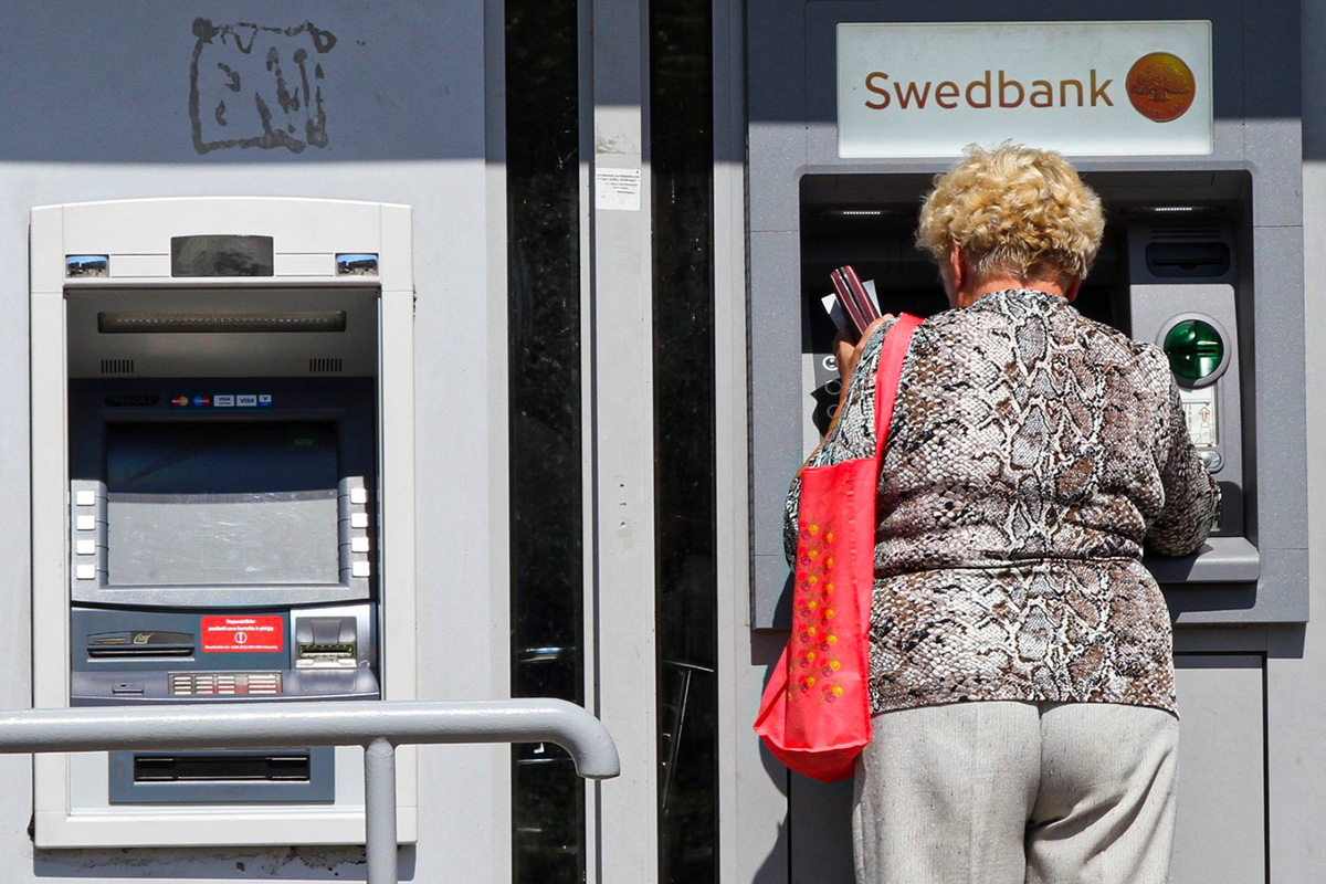 Kobieta przy bankomacie SWEDBANK.