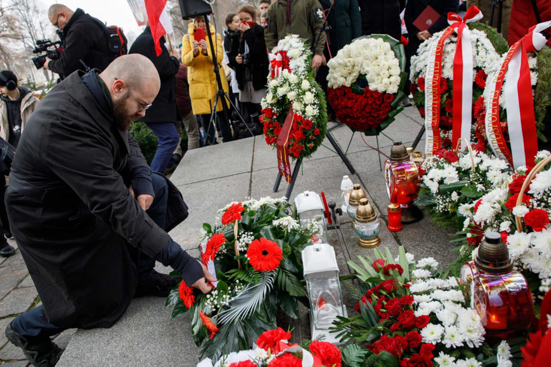 Rajmund Klonowski składa kwiaty na cmentarzu Rossa z okazji 11 listopada.