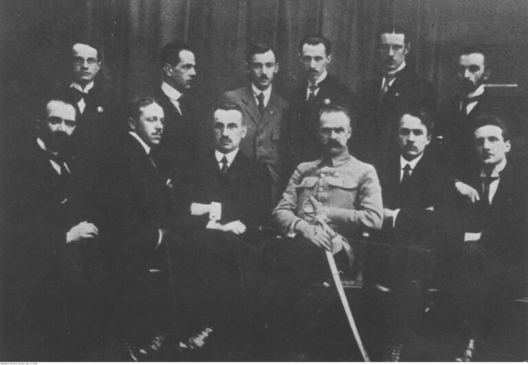 Józef Piłsudski w otoczeniu członków Polskiej Organizacji Wojskowej. Widoczni m.in.: Marian Zyndram Kościałkowski (stoi trzeci z lewej), Bogusław Miedziński (stoi trzeci z prawej), Józef Piłsudski (siedzi w jasnym mundurze), Kazimierz Sosnkowski (siedzi trzeci z lewej).