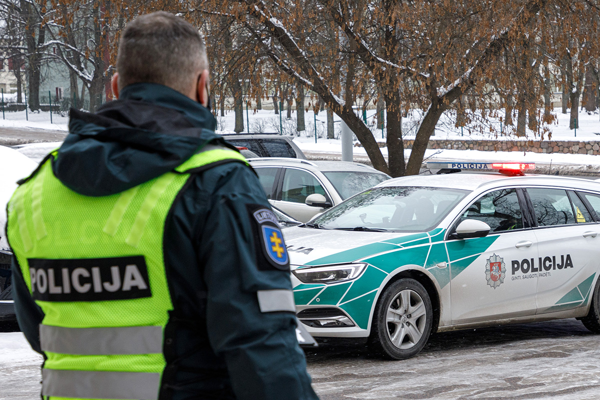 Policjant obok radiowozu.