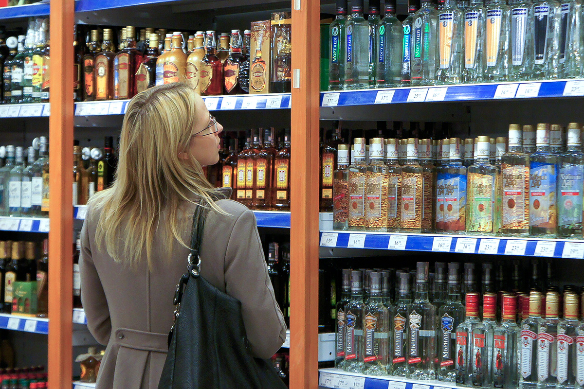 Kobieta w sklepie w dziale sprzedaży alkoholu.