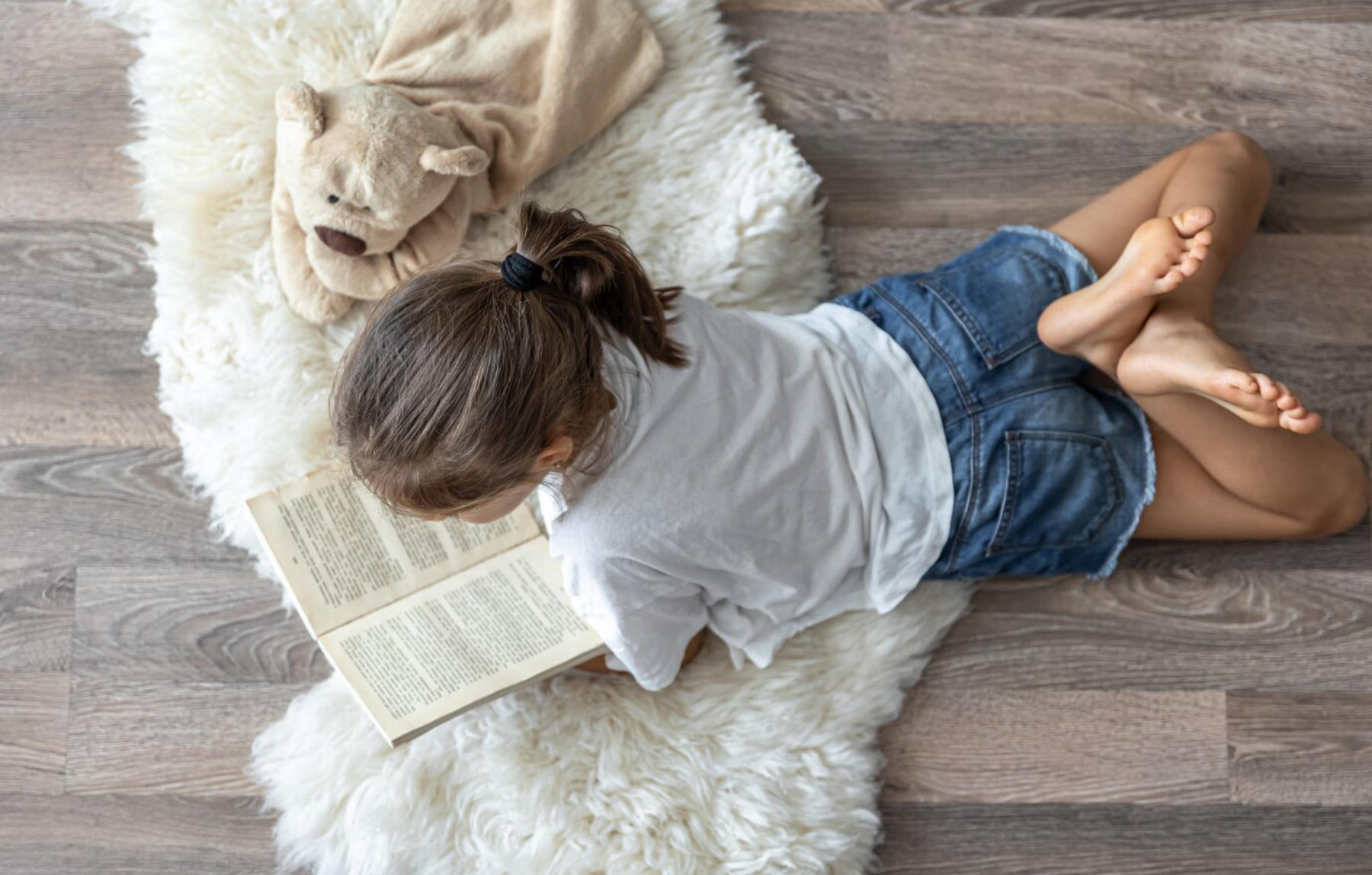 Dziewczynka na podłodze czyta.