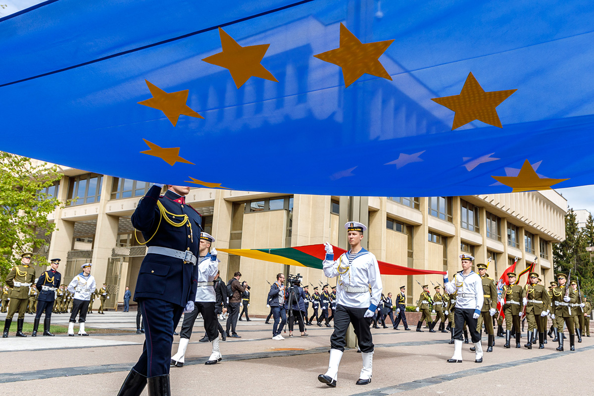 Flagi Litwy i Unii Europejskiej niosą żołnierze.
