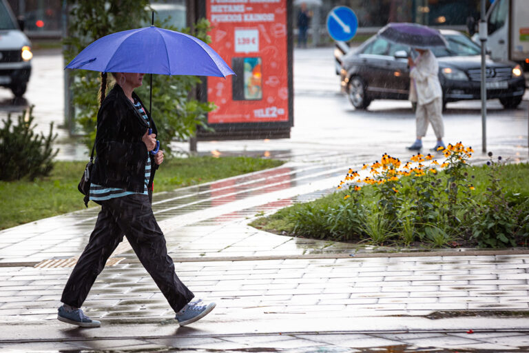 Kobieta z parasolem na ulicy.
