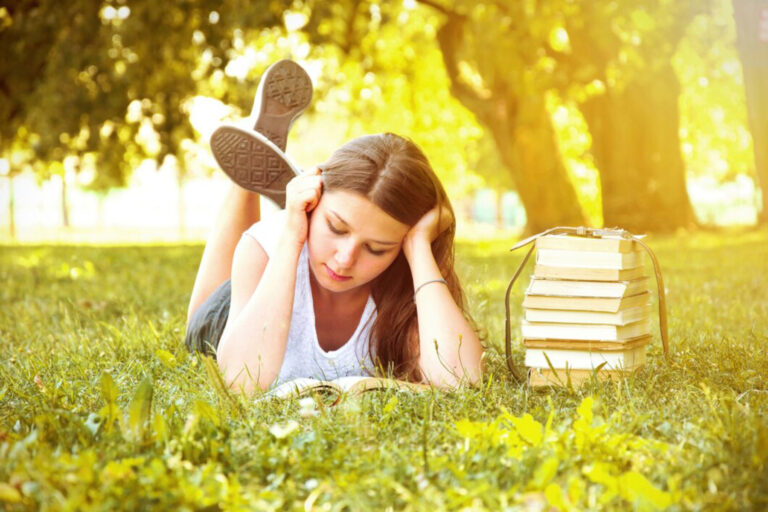 Dziewczynka czytająca na łące.
