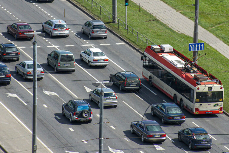 Potok samochodów oraz trolejbus na ulicy.