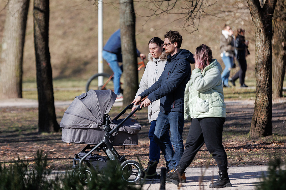 Rodzice z dziećmi w wózkach na spacerze.