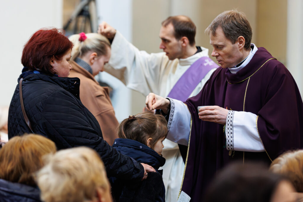 Księża posypują głowy popiołem.