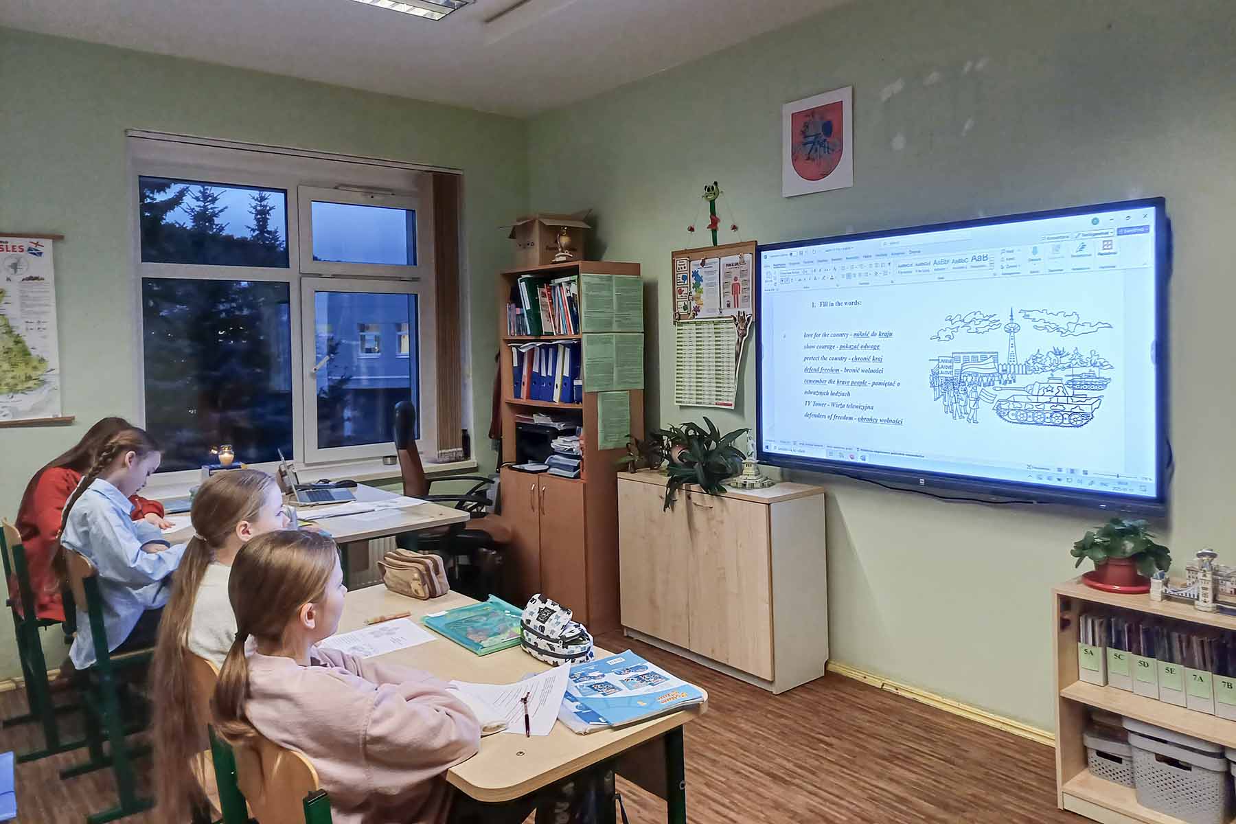 Dzieci na lekcji patrzą na ekran.