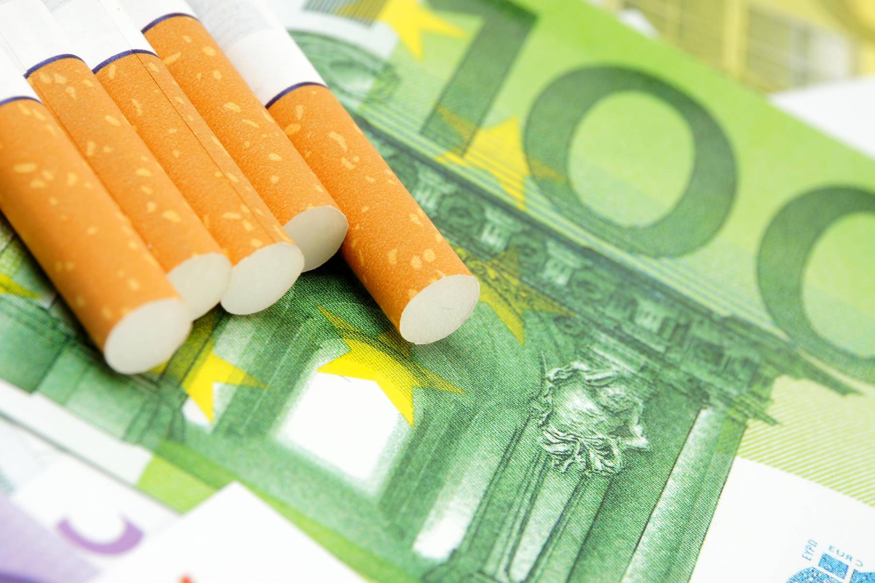Papierosy leżą na 100 Eurach.