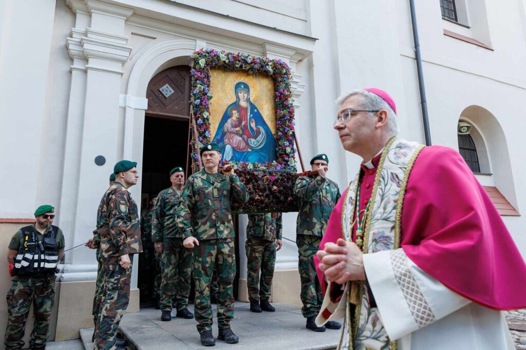 Ksiądz oraz strzelcy obok kościoła w Trokach.