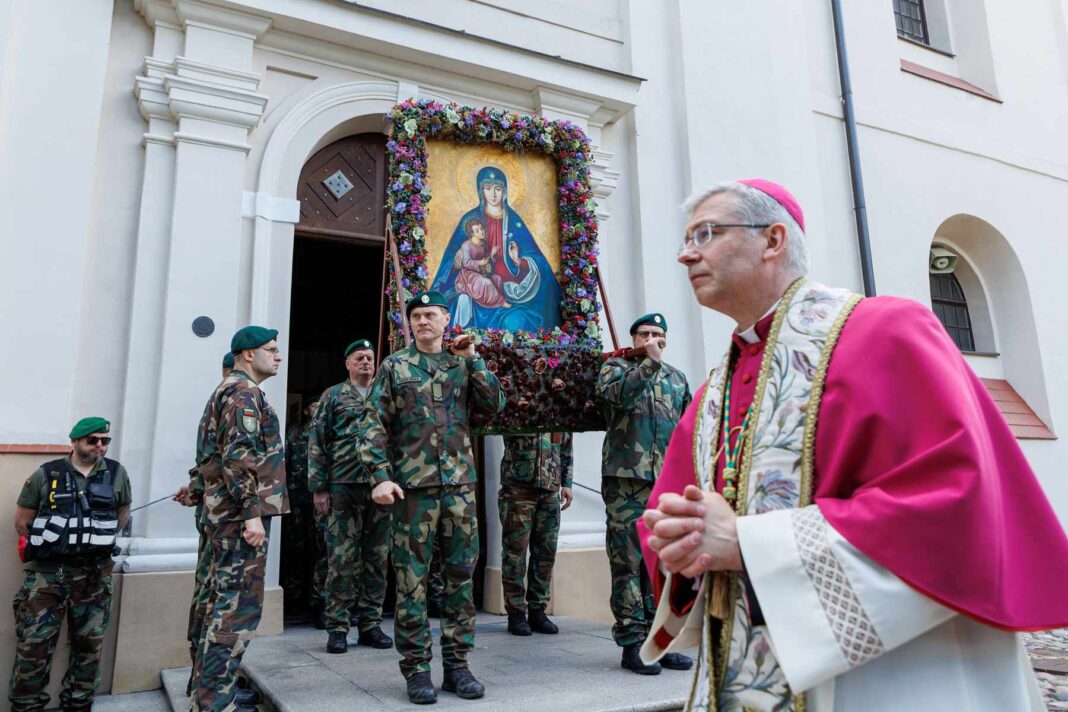Ksiądz oraz strzelcy obok kościoła w Trokach.