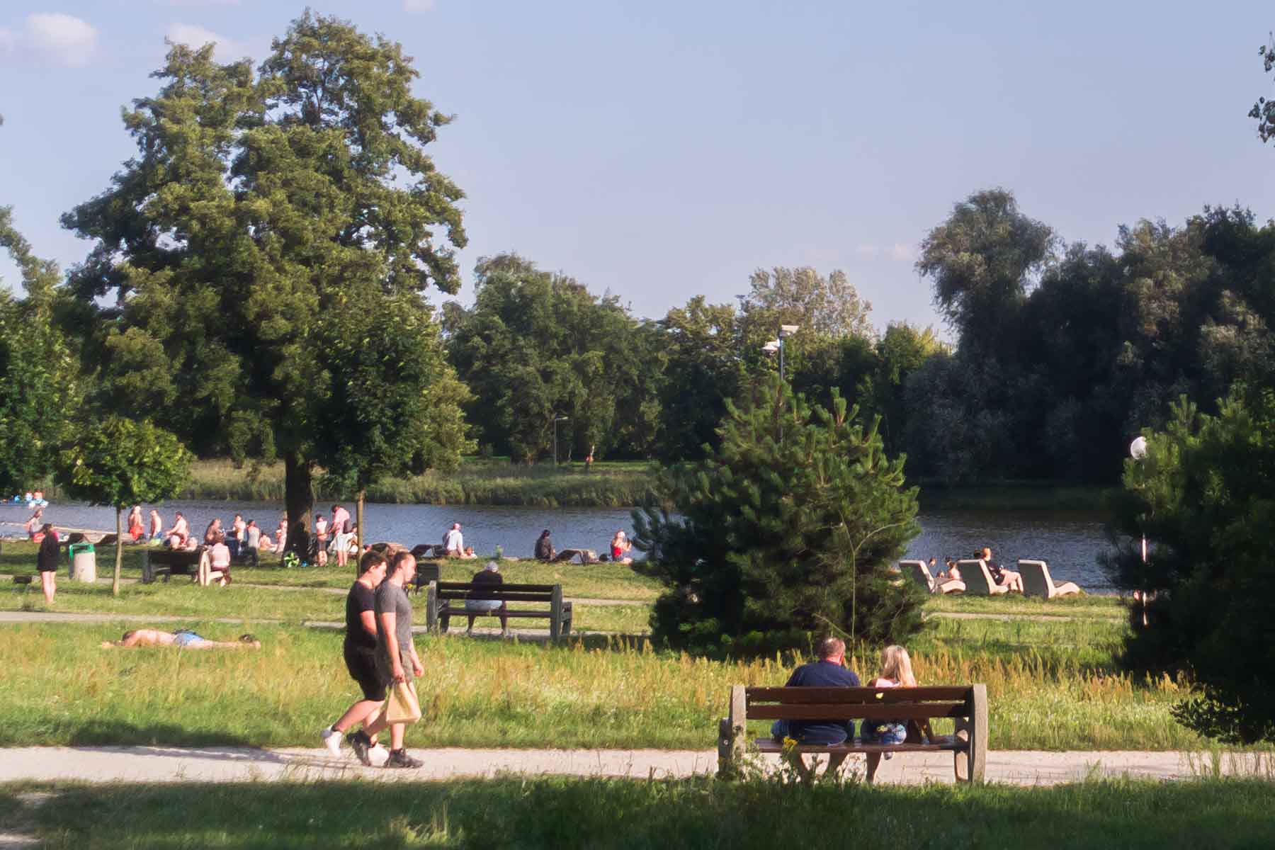 Ludzie w parku nad jeziorem.