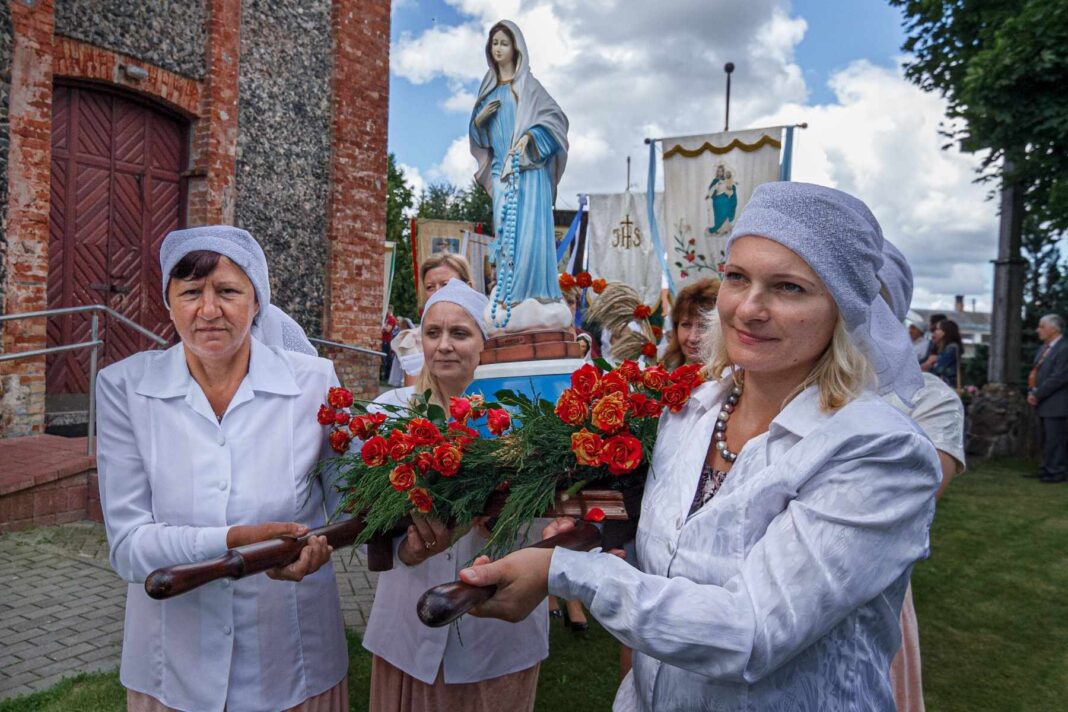 Kobiety niosą posąg Matki Bożej.