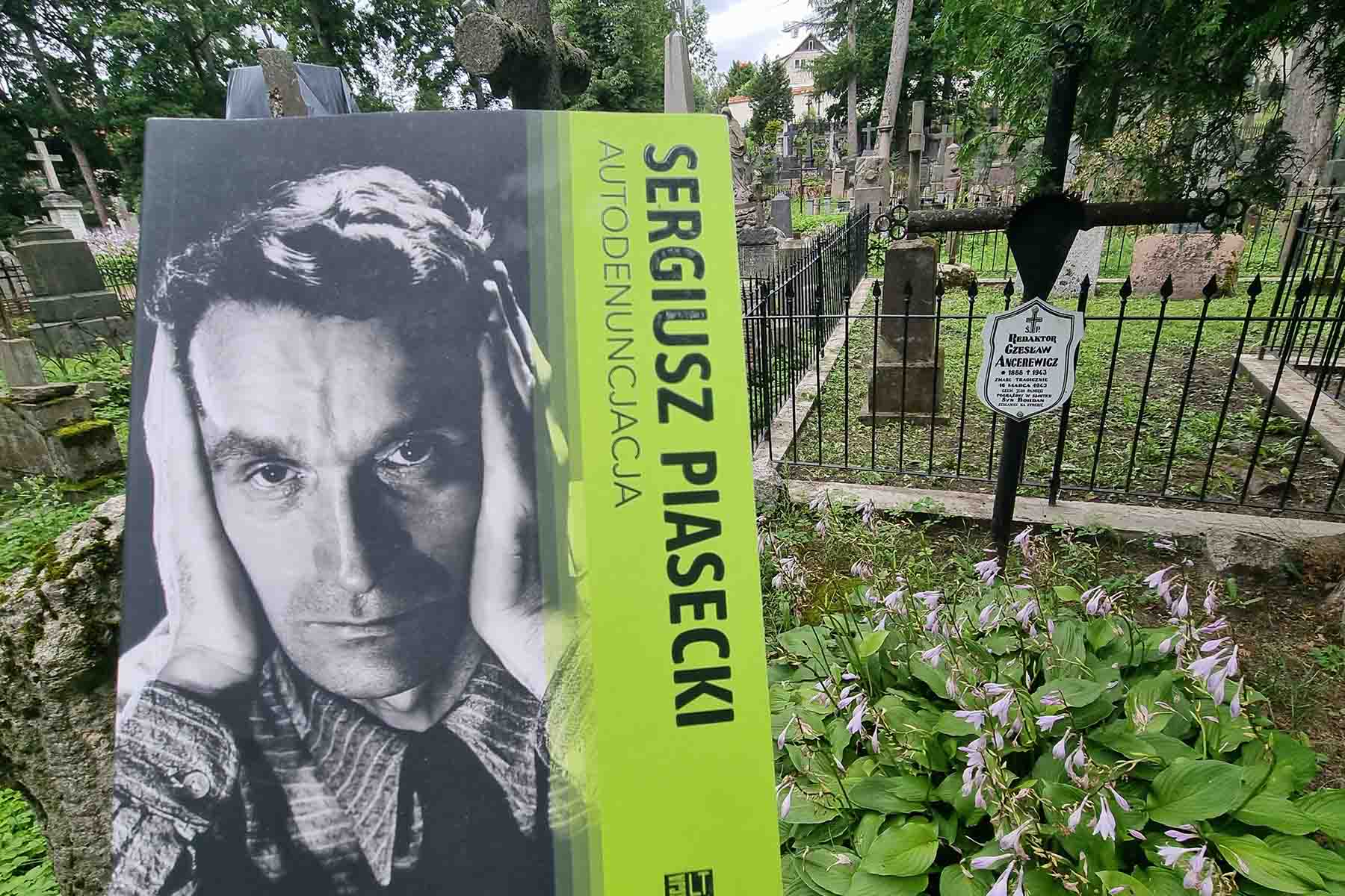 Wojciech Jaskuła z książką przy grobie Czesława Ancerewicza, zabitego przez egzekutywę AK kierowaną przez Sergiusza Piaseckiego.