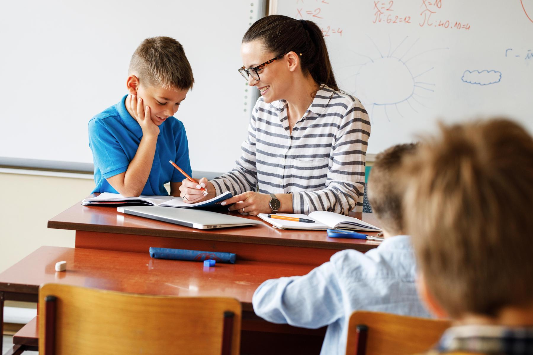 Nauczycielka pomaga uczniowi w nauce.