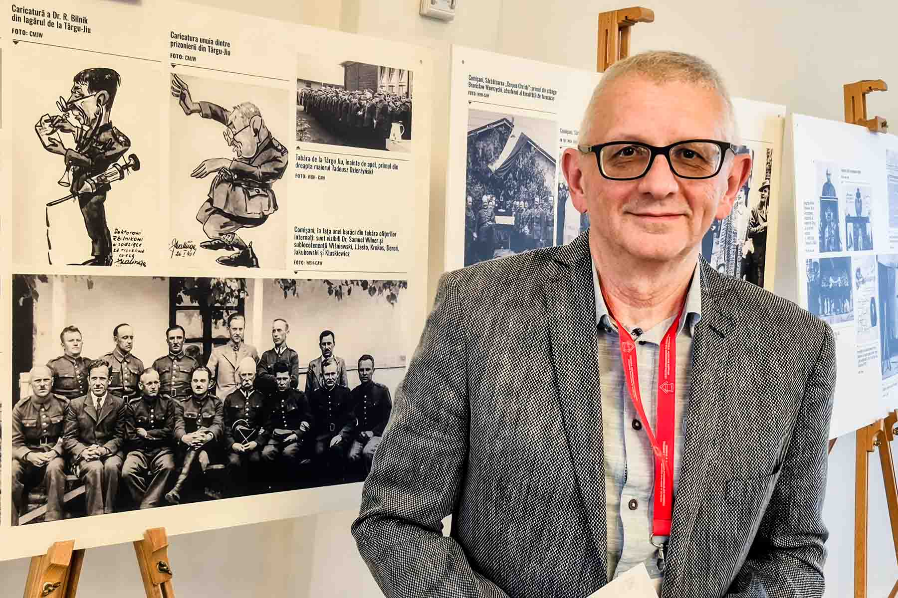 Prof. Henryk Walczak na tle wystawy.