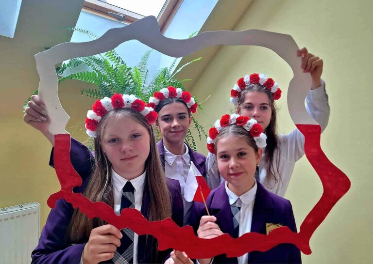 Uczniowie w biało-czerwonych wianuszkach.