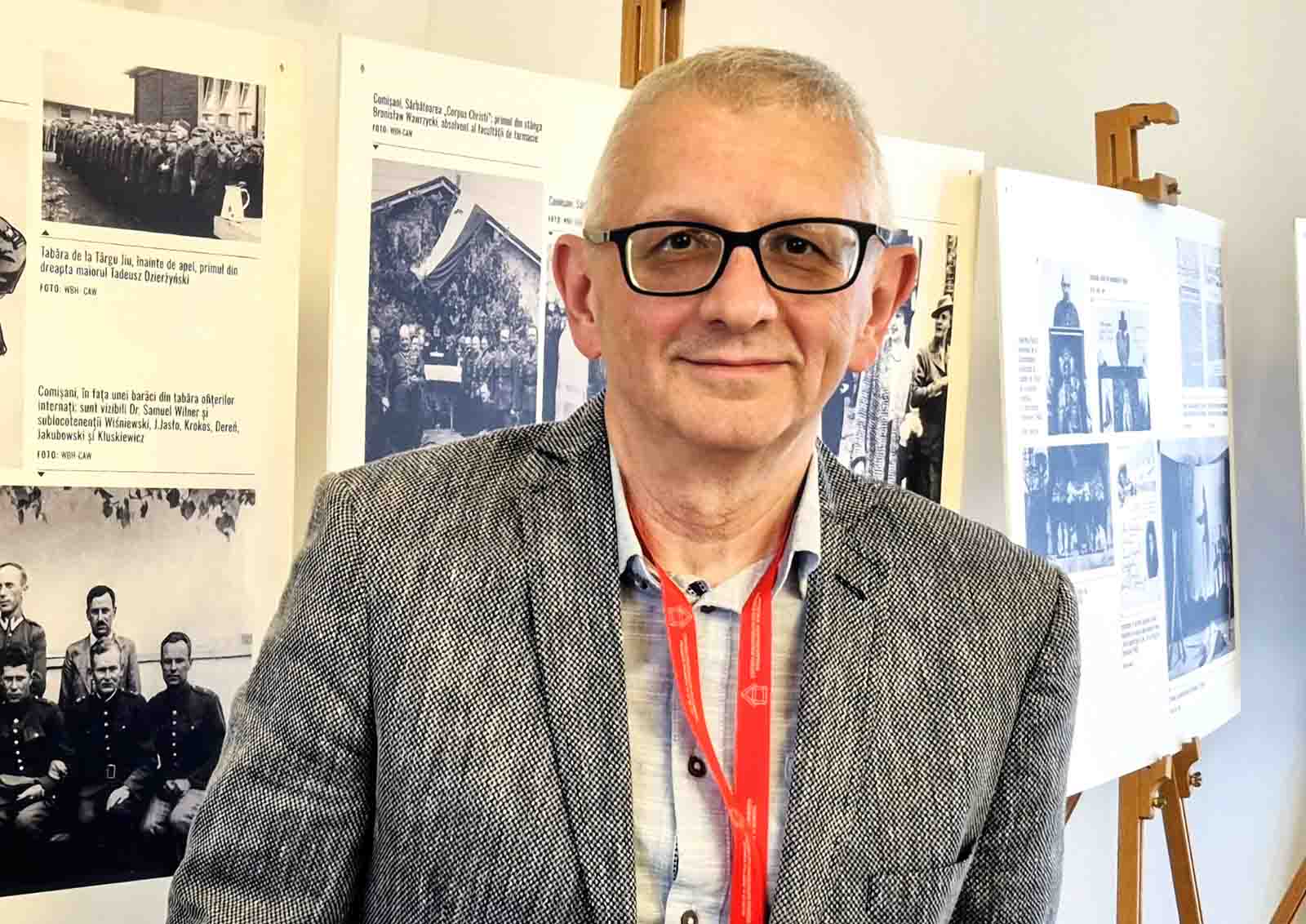 Prof. Henryk Walczak na tle wystawy.