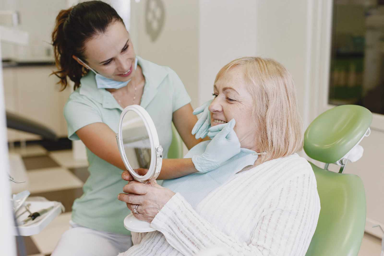 Dentist looking her old patient with tools