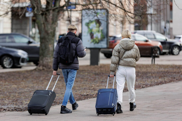 Para z walizkami na kółkach.