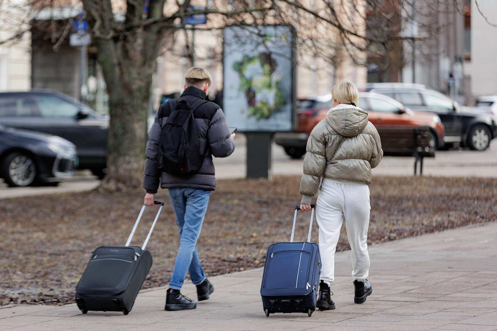 Para z walizkami na kółkach.