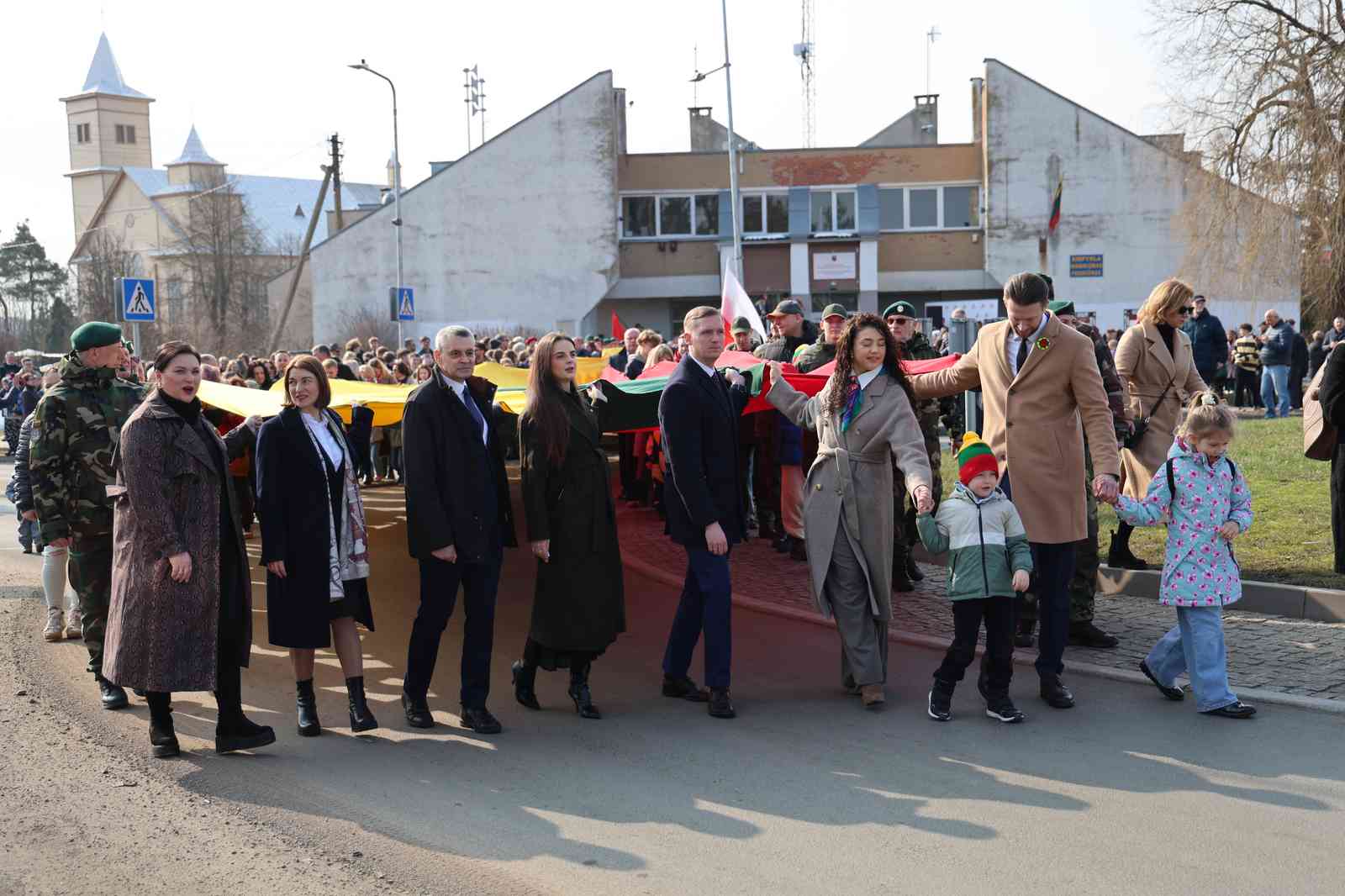 Uroczysty pochód ulicami Rudomina. Na czele pochodu uczestnicy nieśli 150-metrową trójkolorową flagę państwa litewskiego.