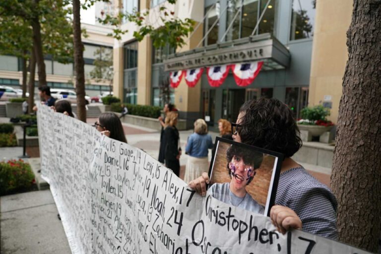 Rodzice protestujący przeciwko korporacji w USA trzymają transparenty z wizerunkami i imionami swoich dzieci, których już nie ma.