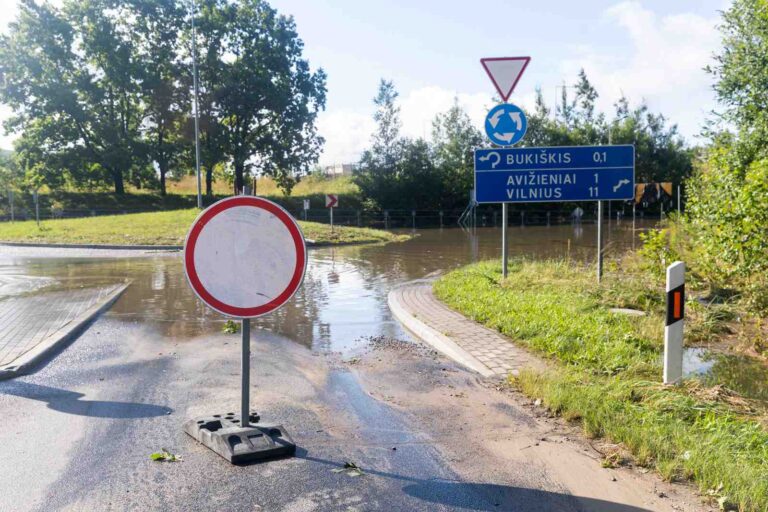 Znak „Zatrzymać się” na zalanym odcinku drogi.