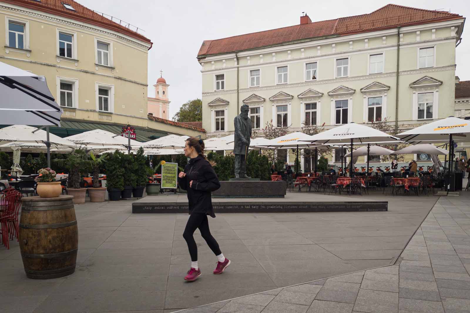 Biegnąca kobieta na starówce Wilna.