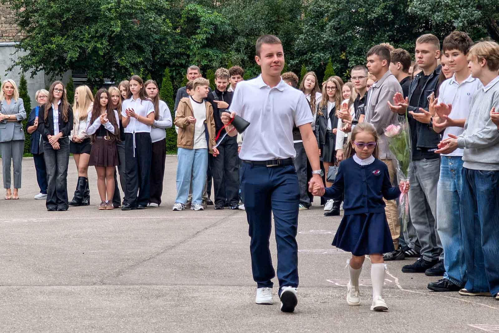 Uczeń starszych klas z pierwszoklasistką z dzwonkiem na 1 września.