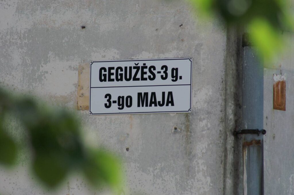 Dom z tabliczką adresu po litewsku i polsku.