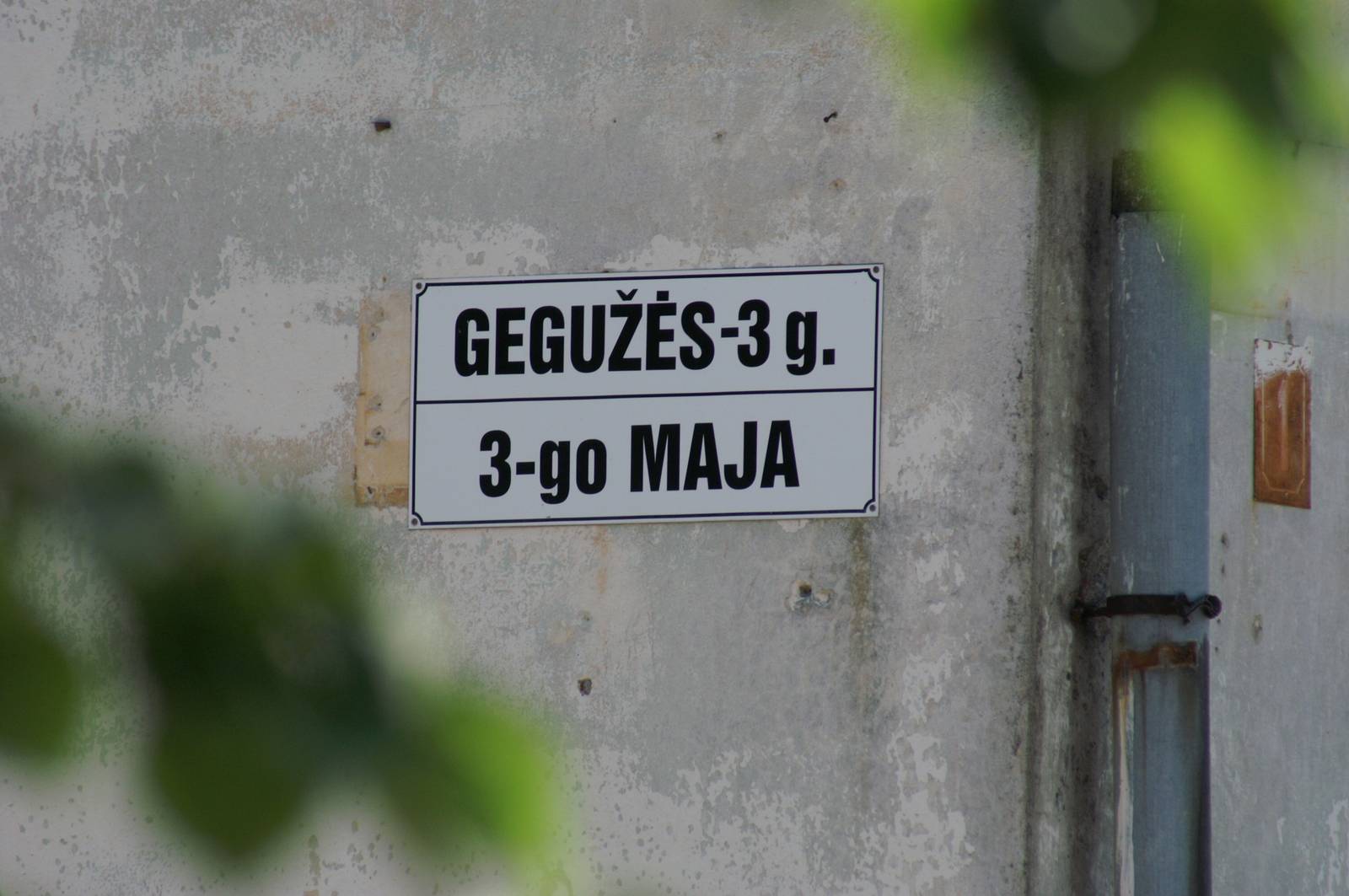 Dom z tabliczką adresu po litewsku i polsku.