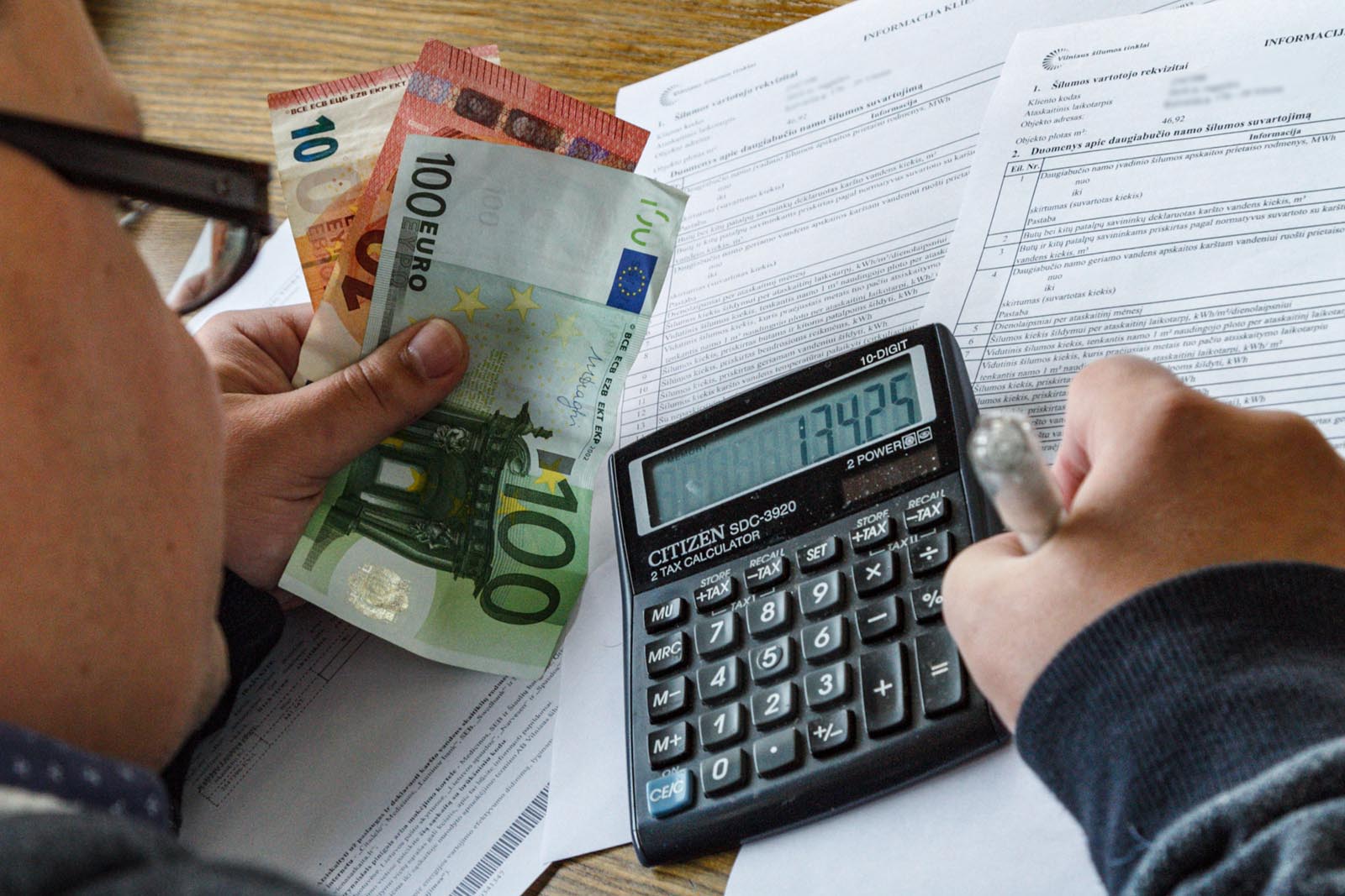 SPOL-ogrzewanie-2026-10-20 Pieniądze i kalkulator w rękach.