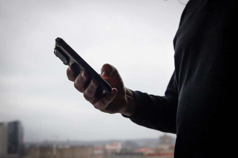 Zaciemniona osoba z smartfonem.