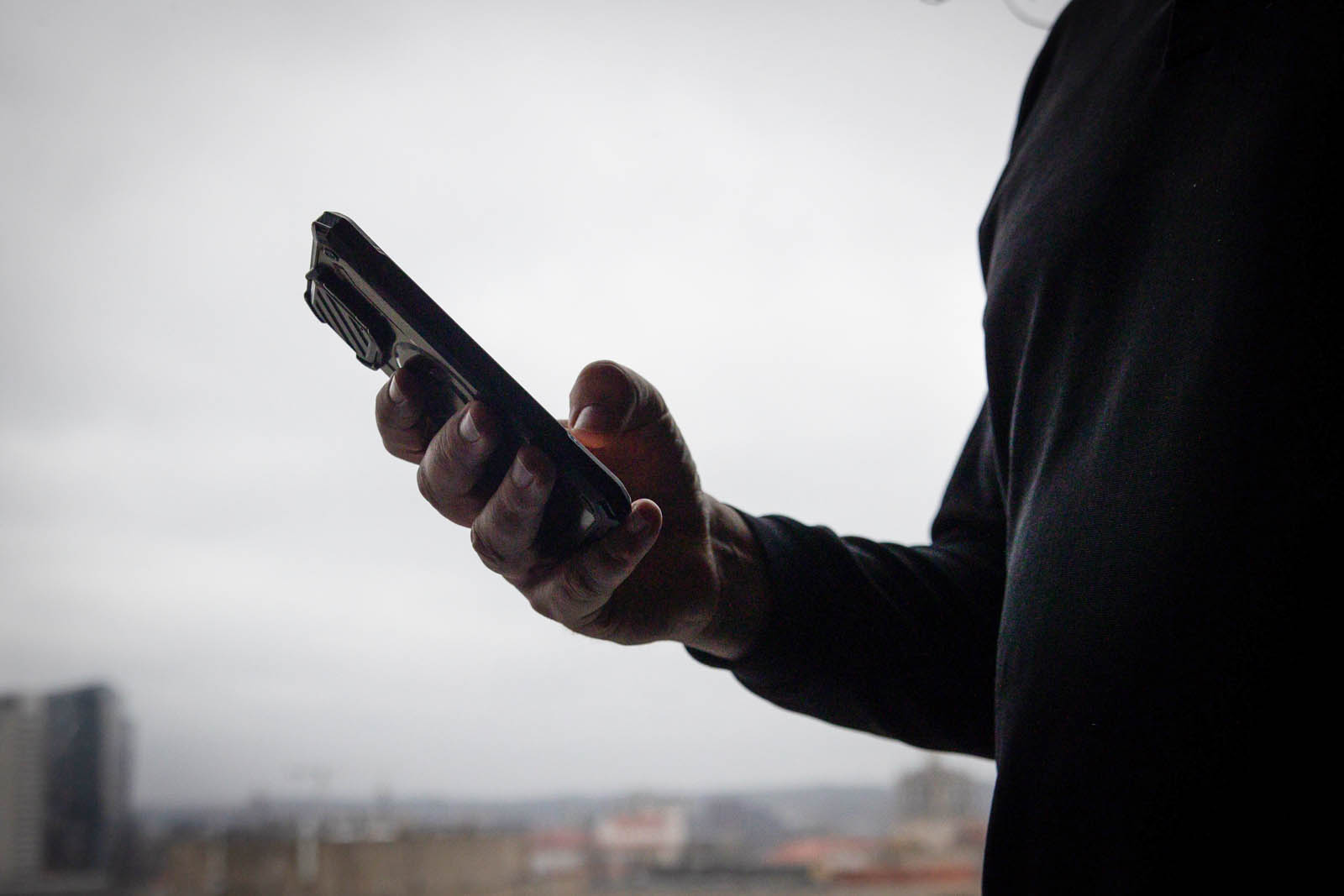 Zaciemniona osoba z smartfonem.