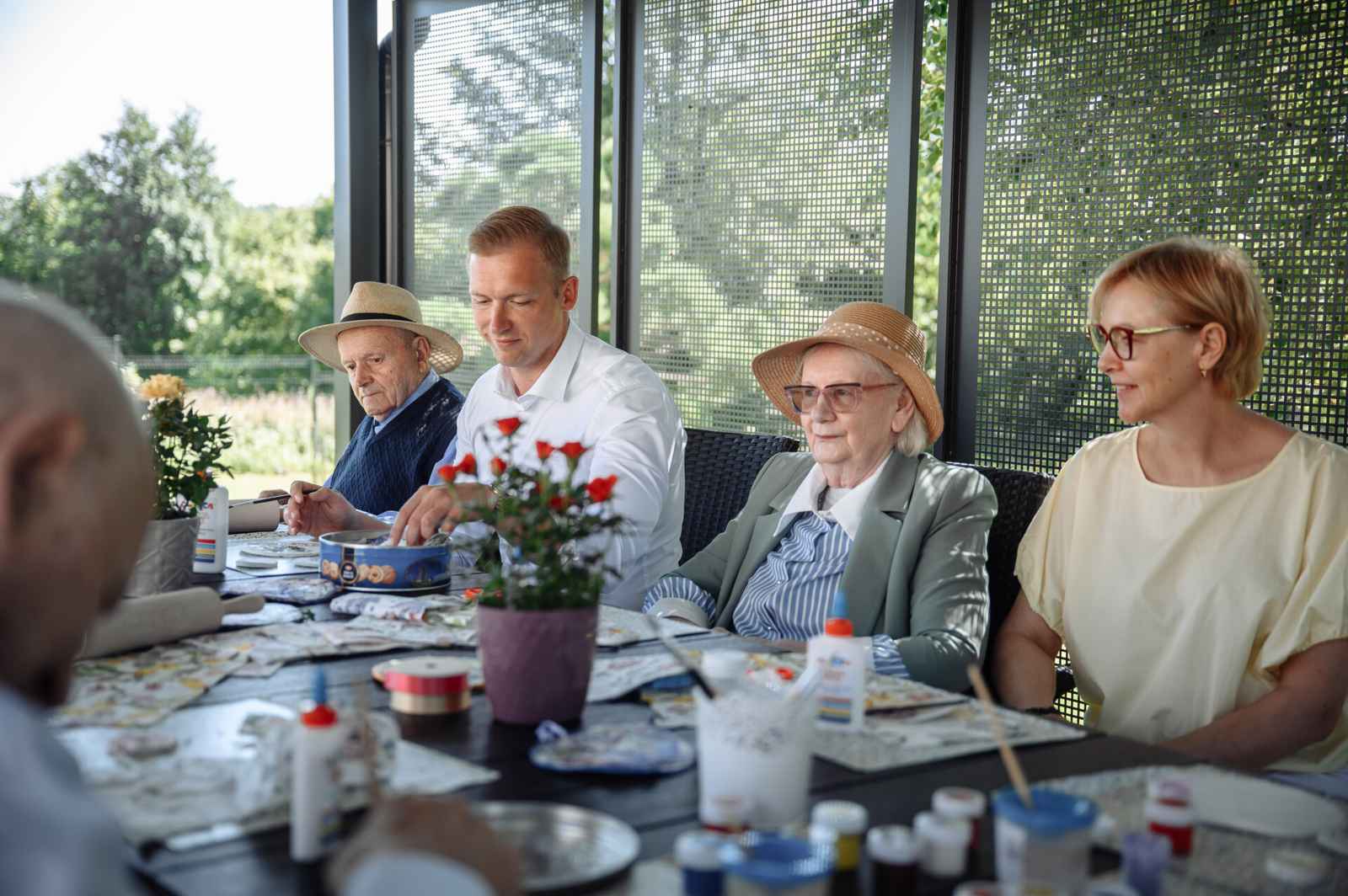 Seniorzy na warsztatach za stołem.