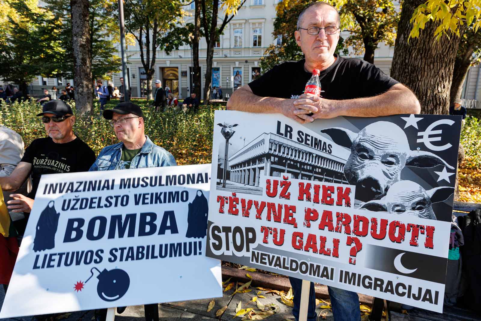 Uczestnicy protestu przeciwko masowej imigracji z transparentami na Placu Vincasa Kudirki w Wilnie.